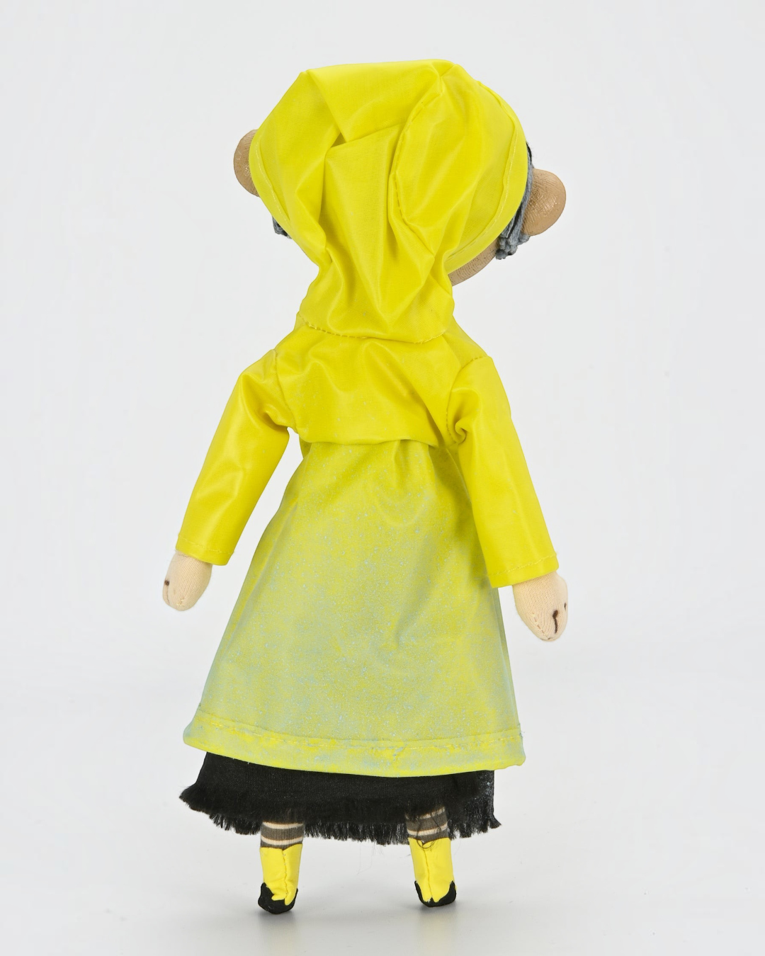 VaultifyUK Coraline 10-inch prop replica doll wearing a yellow hooded raincoat, seen from the back.