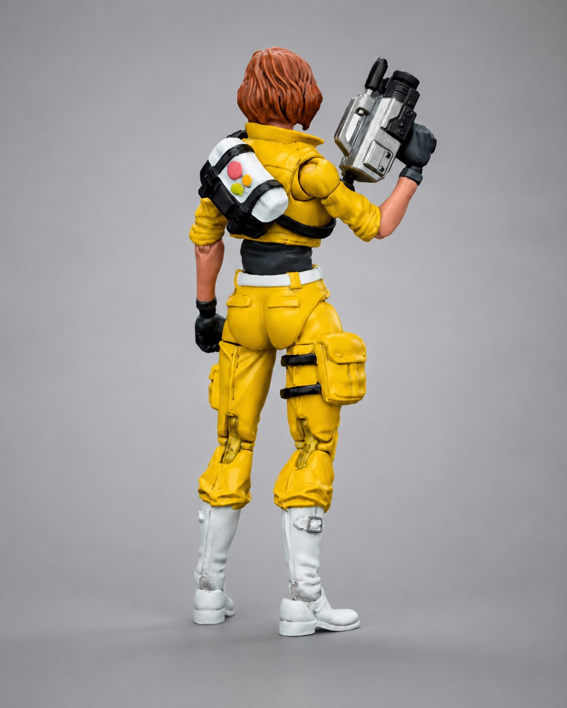 Rear view of the JoyToy TMNT April O’Neil figure showing her equipment bag, camera and yellow outfit