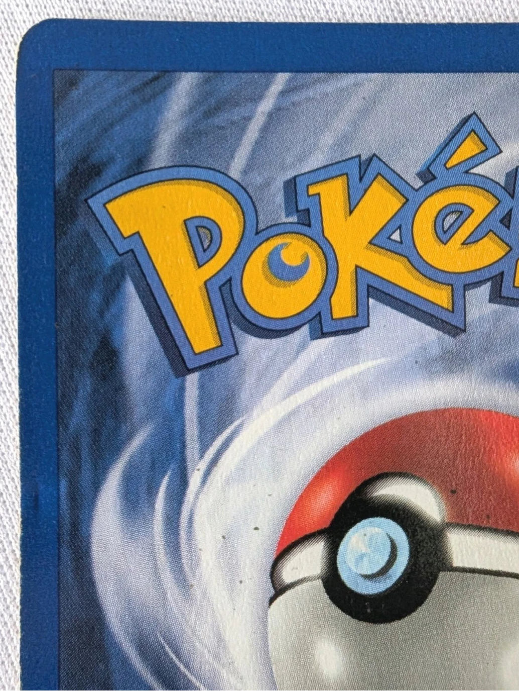 Close-up of a Pokémon trading card with the Pokémon logo and ball design.