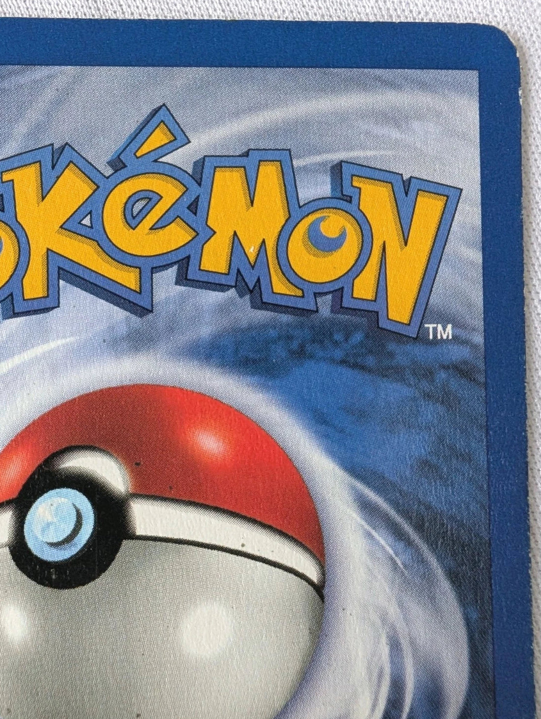 Close-up of a Pokémon trading card with a Poké Ball design on a white background