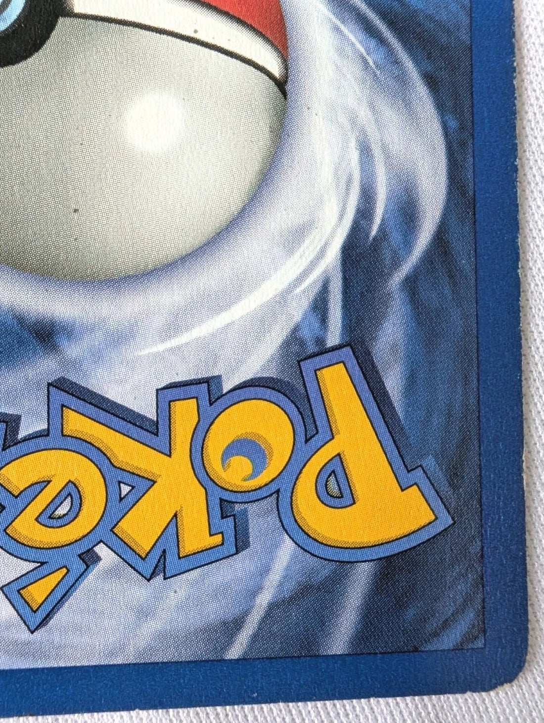 Close-up of a Poké Ball on a Pokémon trading card with blue border