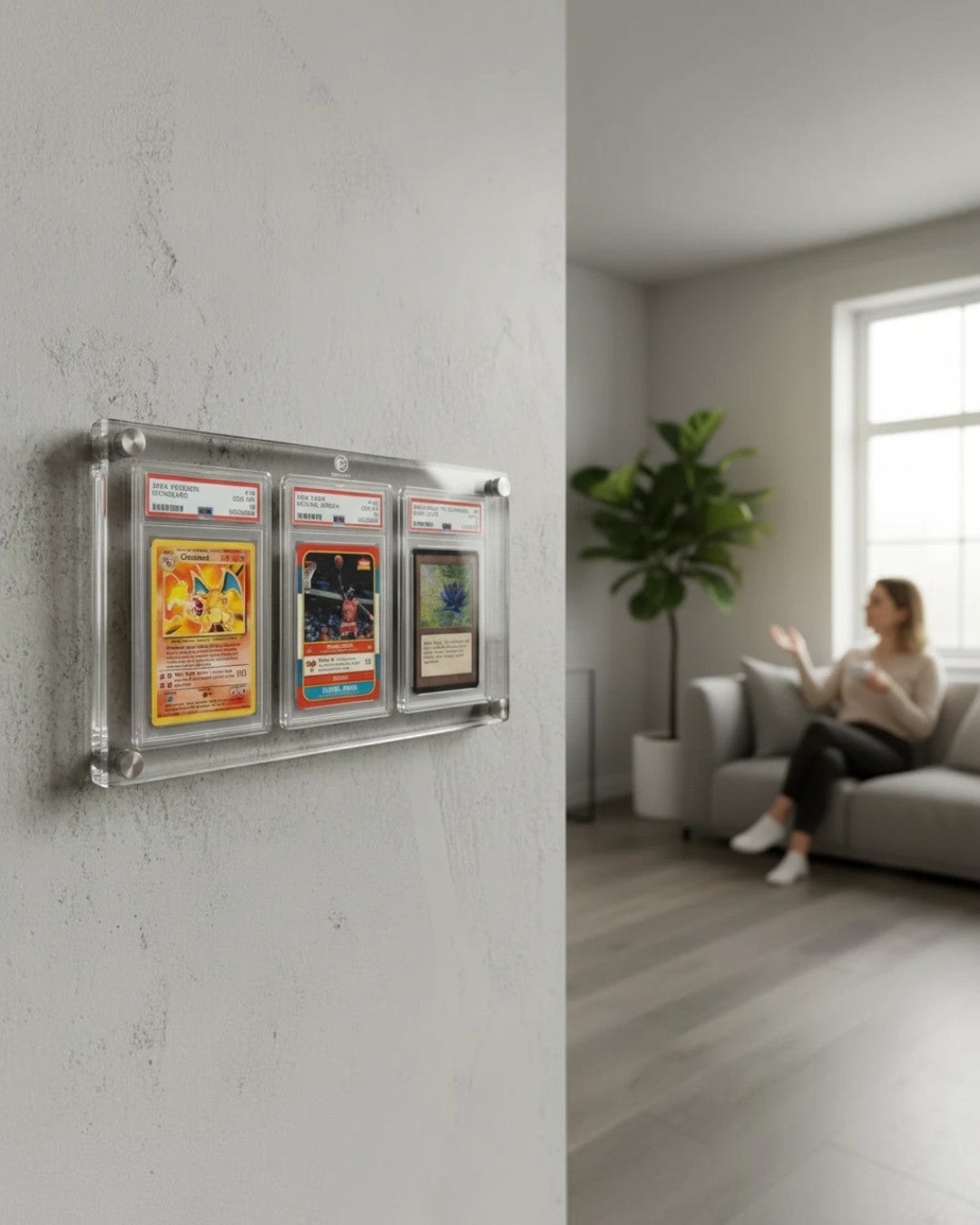 VaultifyUK 3-slab acrylic wall display frame holding three graded trading card slabs mounted on a living room wall