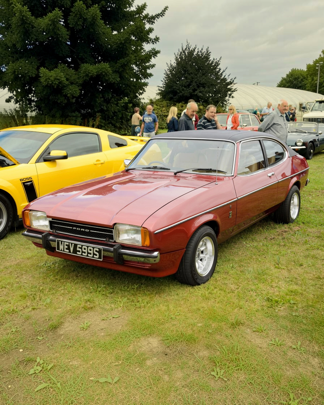 The real Ford Capri Mk2 3.0 Ghia: a red 1977 Capri Ghia 3.0 with dark vinyl roof, front three-quarter view (not the exact car Corgi modelled)