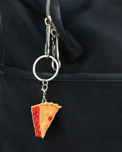 VaultifyUK Critical Role Taste of Exandria cherry pie food charm attached to a black backpack keyring