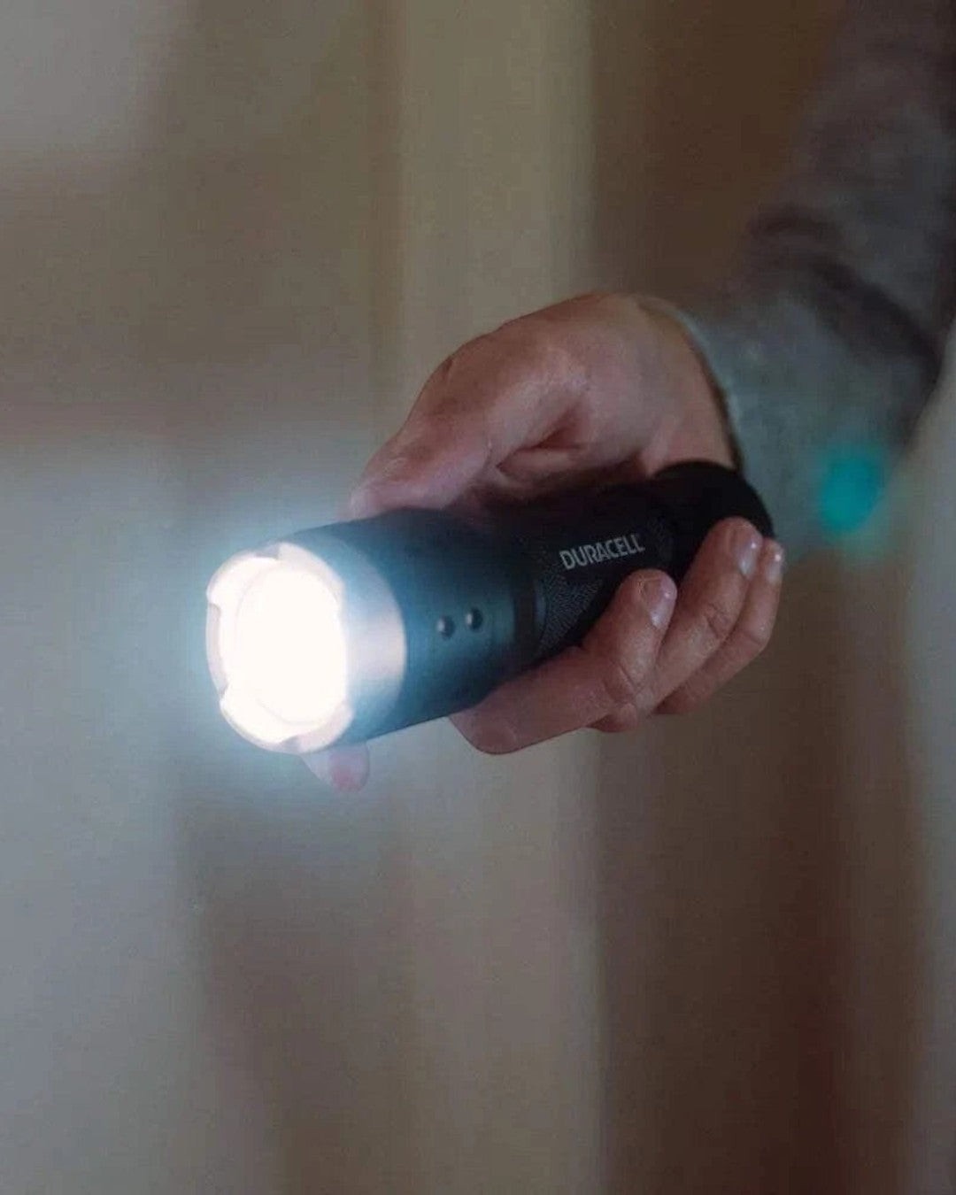 VaultifyUK Duracell 350 lumen LED flashlight with adjustable focus beam held in hand, emitting a bright white light