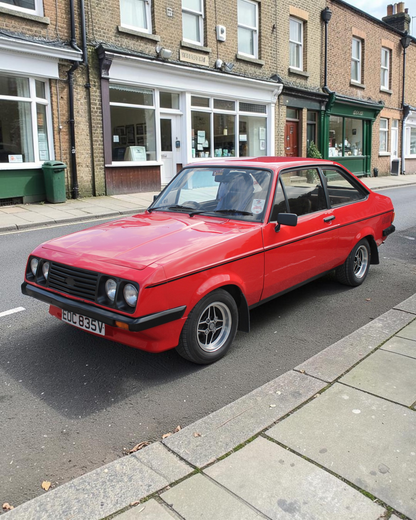 The real Ford Escort Mk2 RS2000: a red RS2000 with black side stripe, front three-quarter view (not the exact car Corgi modelled)