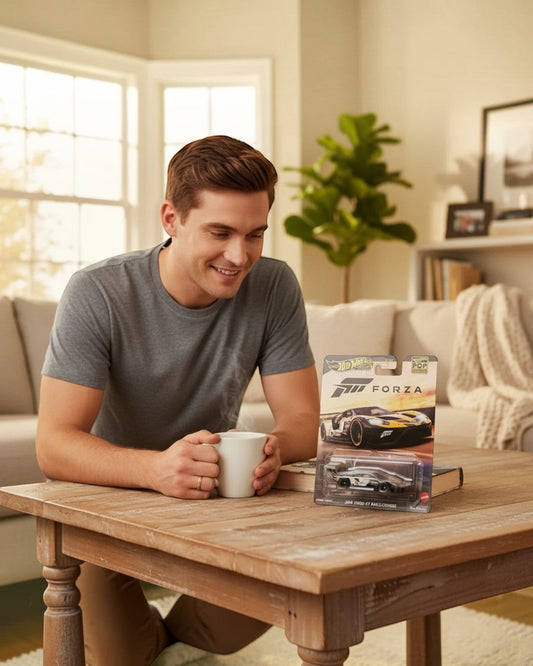 A man smiling at a VaultifyUK Hot Wheels Premium Forza 2016 Ford GT Race die-cast car in its collector packaging.