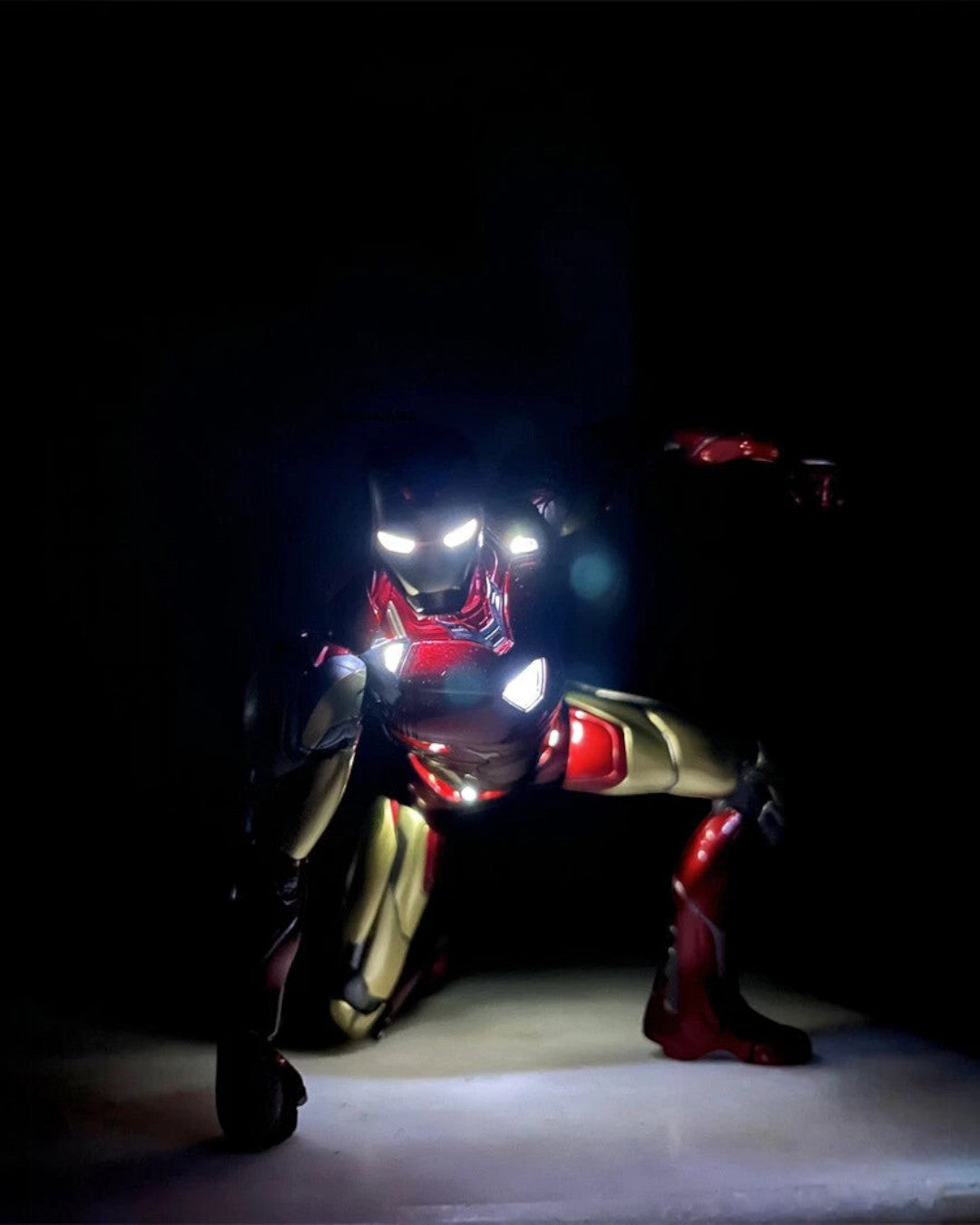 VaultifyUK Iron Man MK85 2.0 figure in a dynamic landing pose with glowing LED arc reactor and eyes in the dark