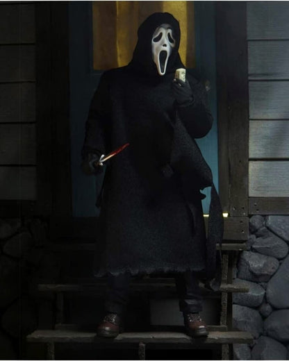 VaultifyUK NECA Ultimate Ghost Face action figure in a black fabric robe holding a knife on a porch at night