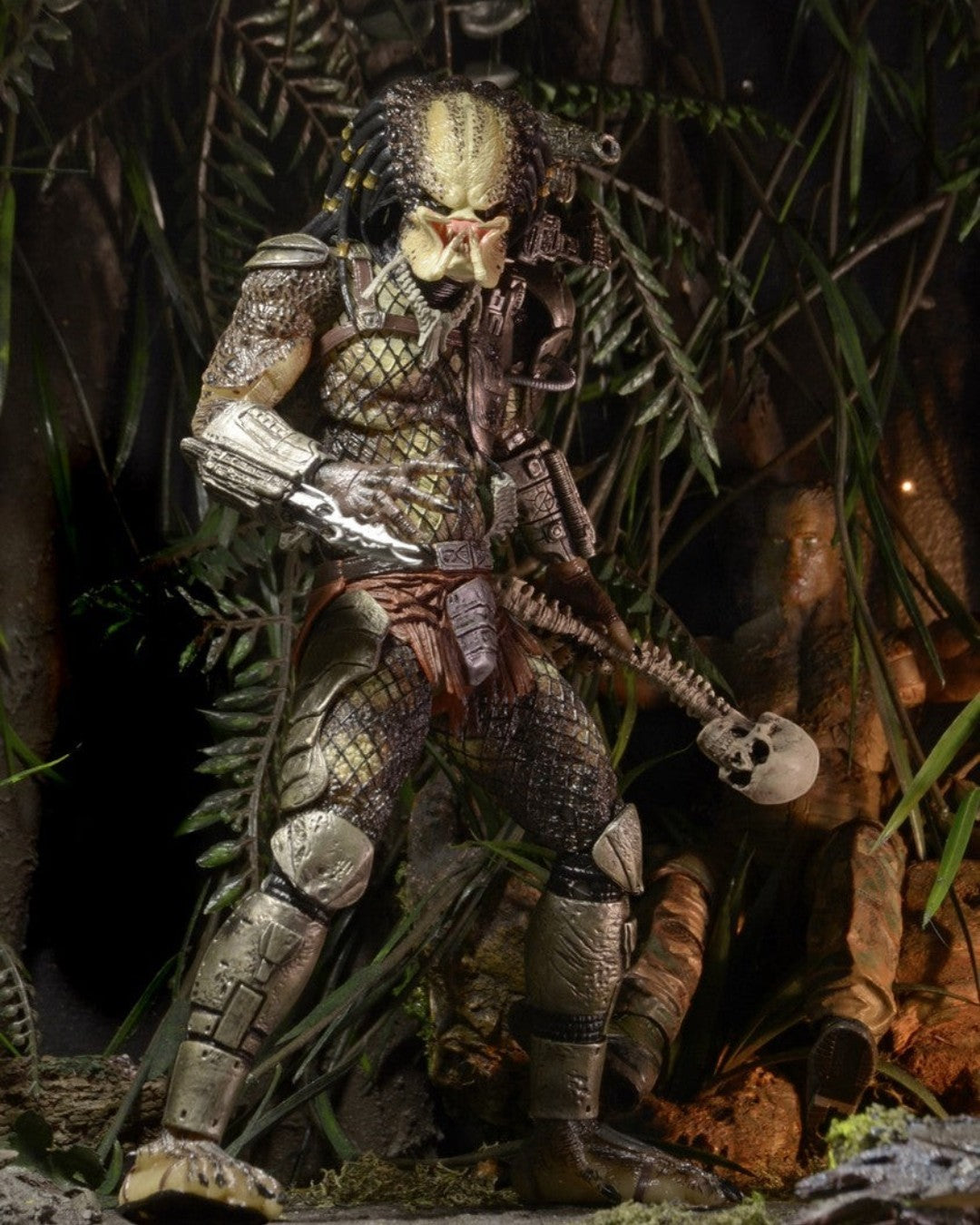 VaultifyUK NECA Jungle Hunter Predator action figure with detailed armour and skull accessory in a jungle setting