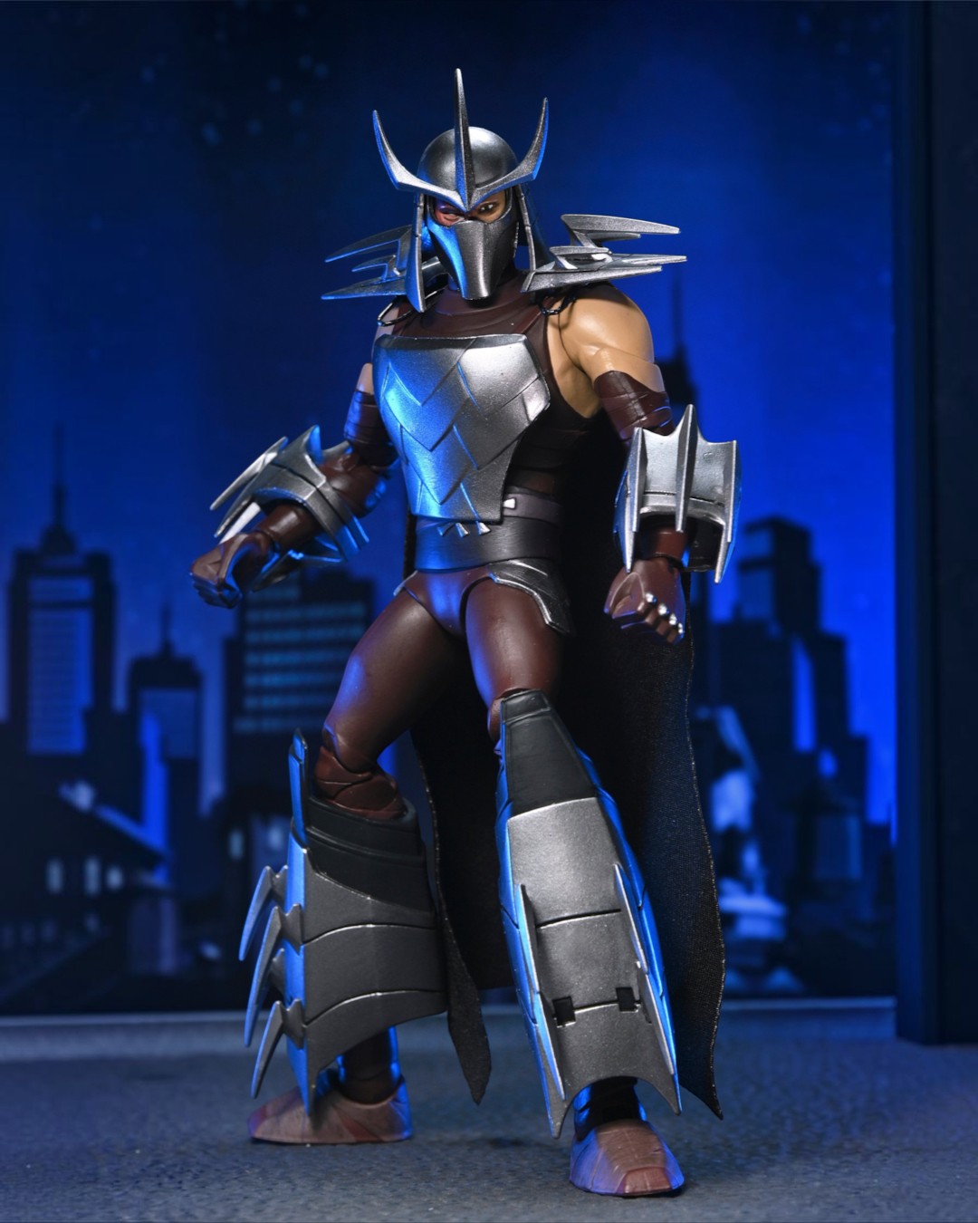 VaultifyUK NECA TMNT Shredder 7-inch action figure with metallic armor, fabric cape, and 2012 cartoon-accurate design.