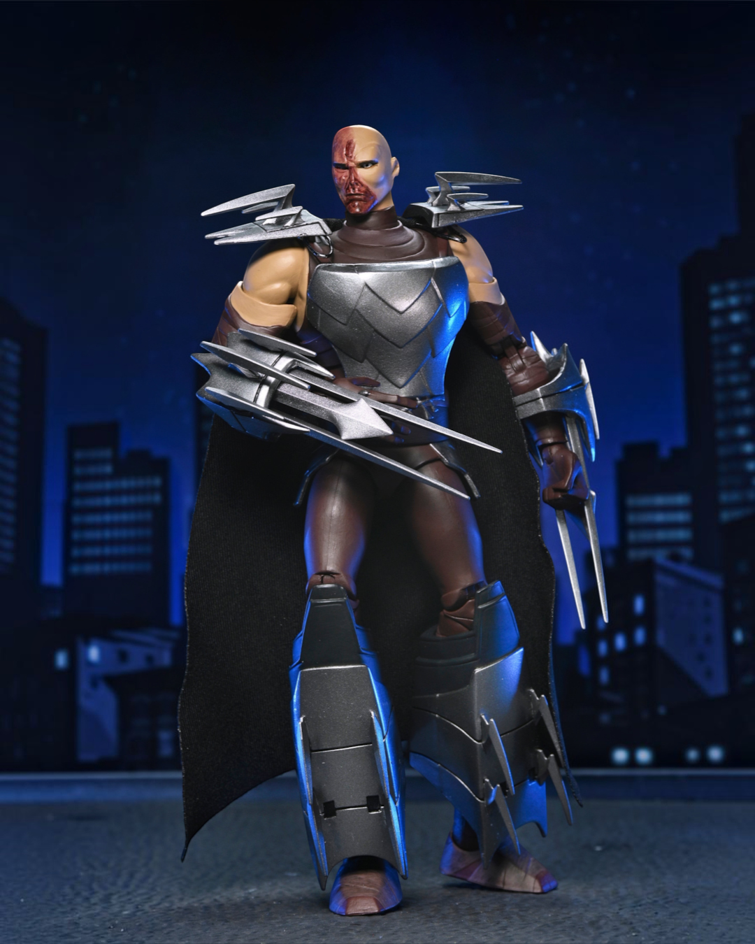 VaultifyUK NECA TMNT 2012 Shredder action figure with battle-damaged face, silver armor, and removable fabric cape.