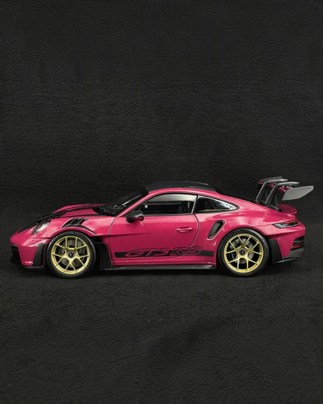 VaultifyUK Schuco 1:18 scale Porsche 911 GT3 RS model car in Rubystar magenta with gold wheels, side profile view.