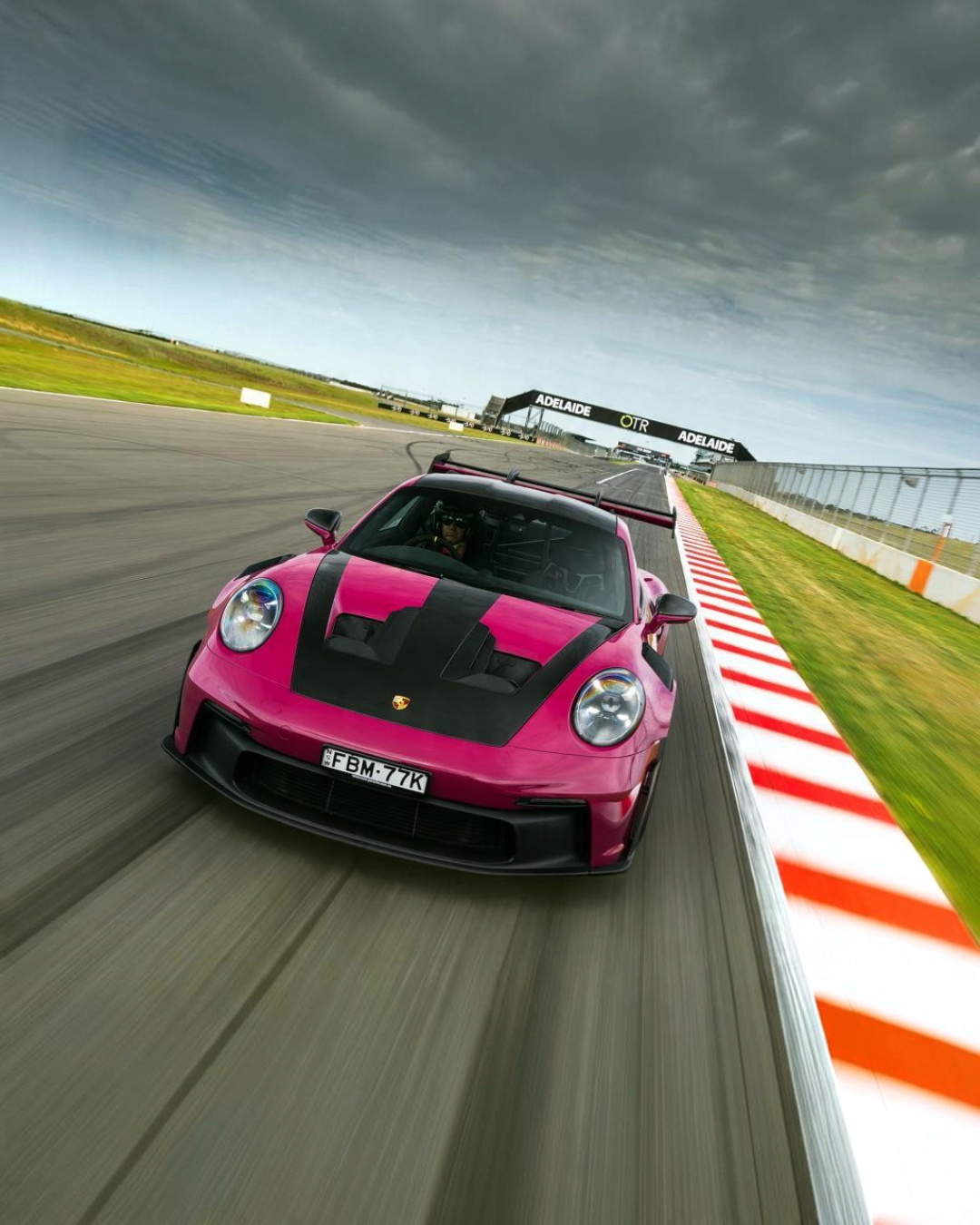VaultifyUK Schuco 1:18 scale Porsche 911 992 GT3 RS model car in vivid Rubystar magenta on a racetrack