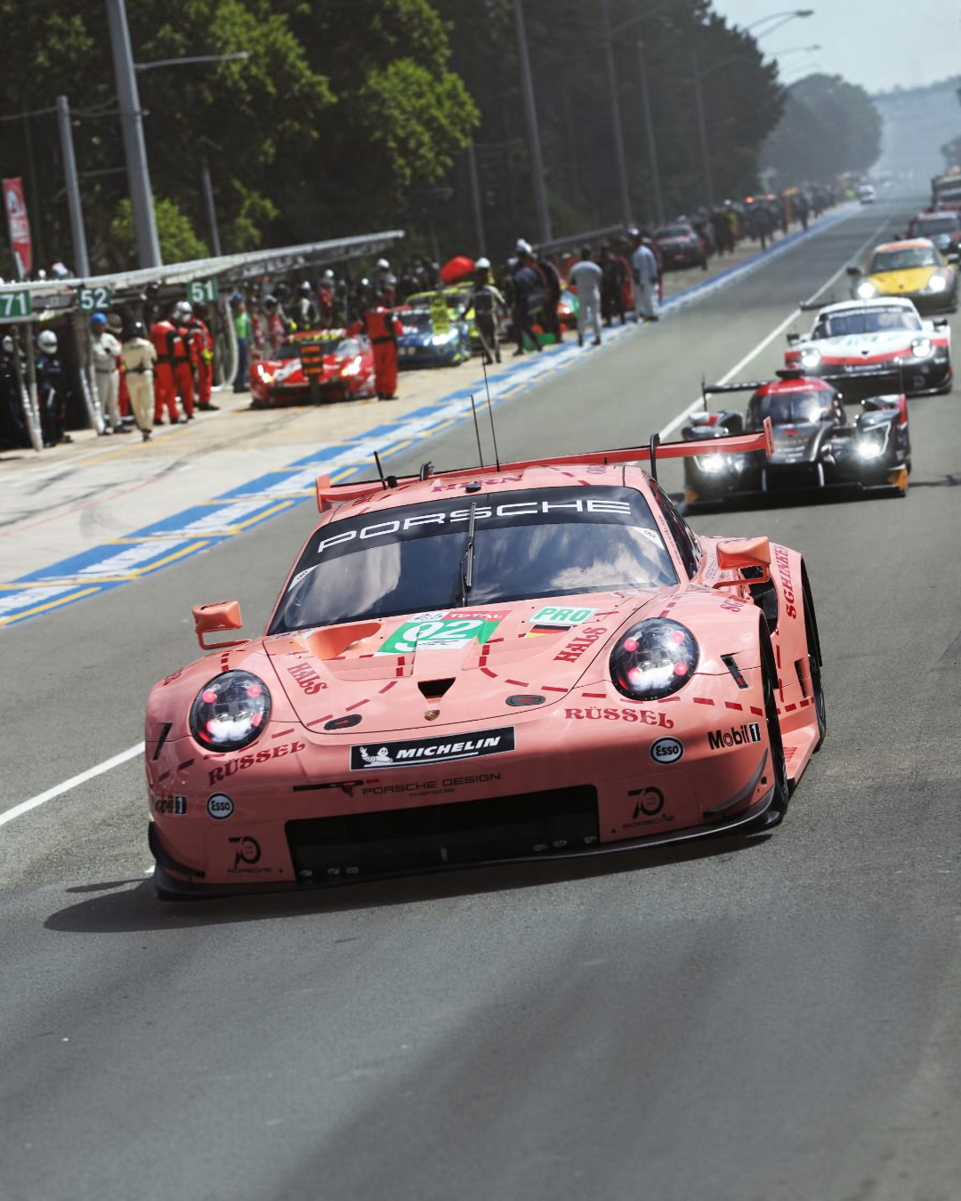 VaultifyUK 1:12 scale IXO Porsche 911 RSR Pink Pig model car featuring iconic butcher-cut livery on a race track