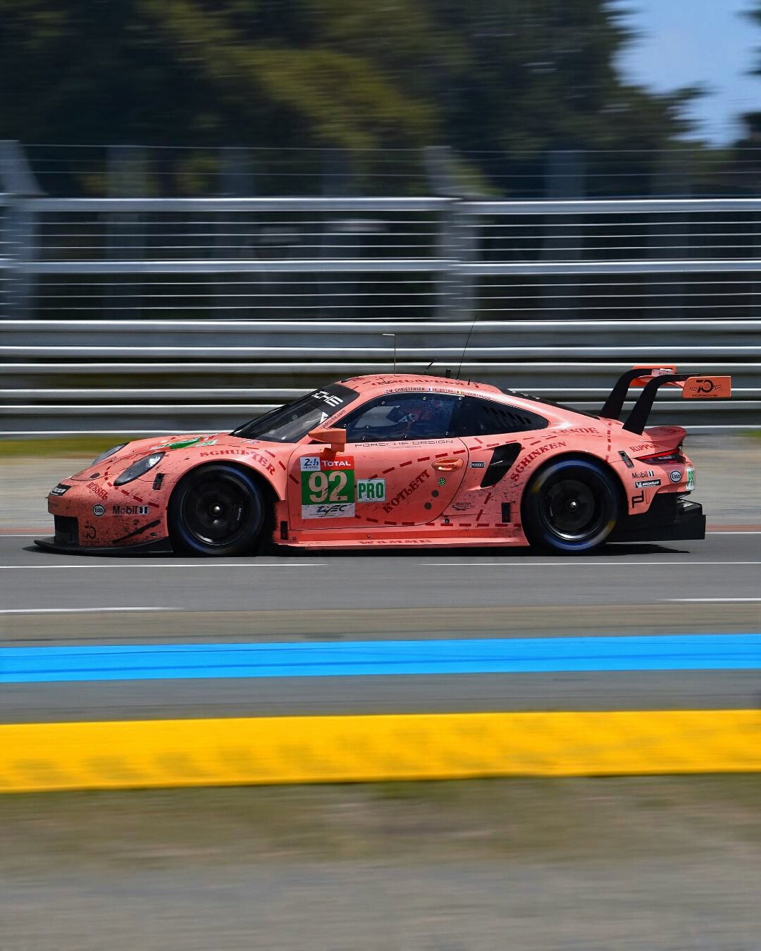 VaultifyUK 1:12 scale IXO Porsche 911 RSR Pink Pig race car model in side profile on a Le Mans track