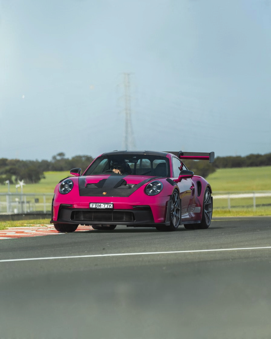 VaultifyUK Schuco 1:18 scale Porsche 911 GT3 RS model in Rubystar magenta driving on a race track