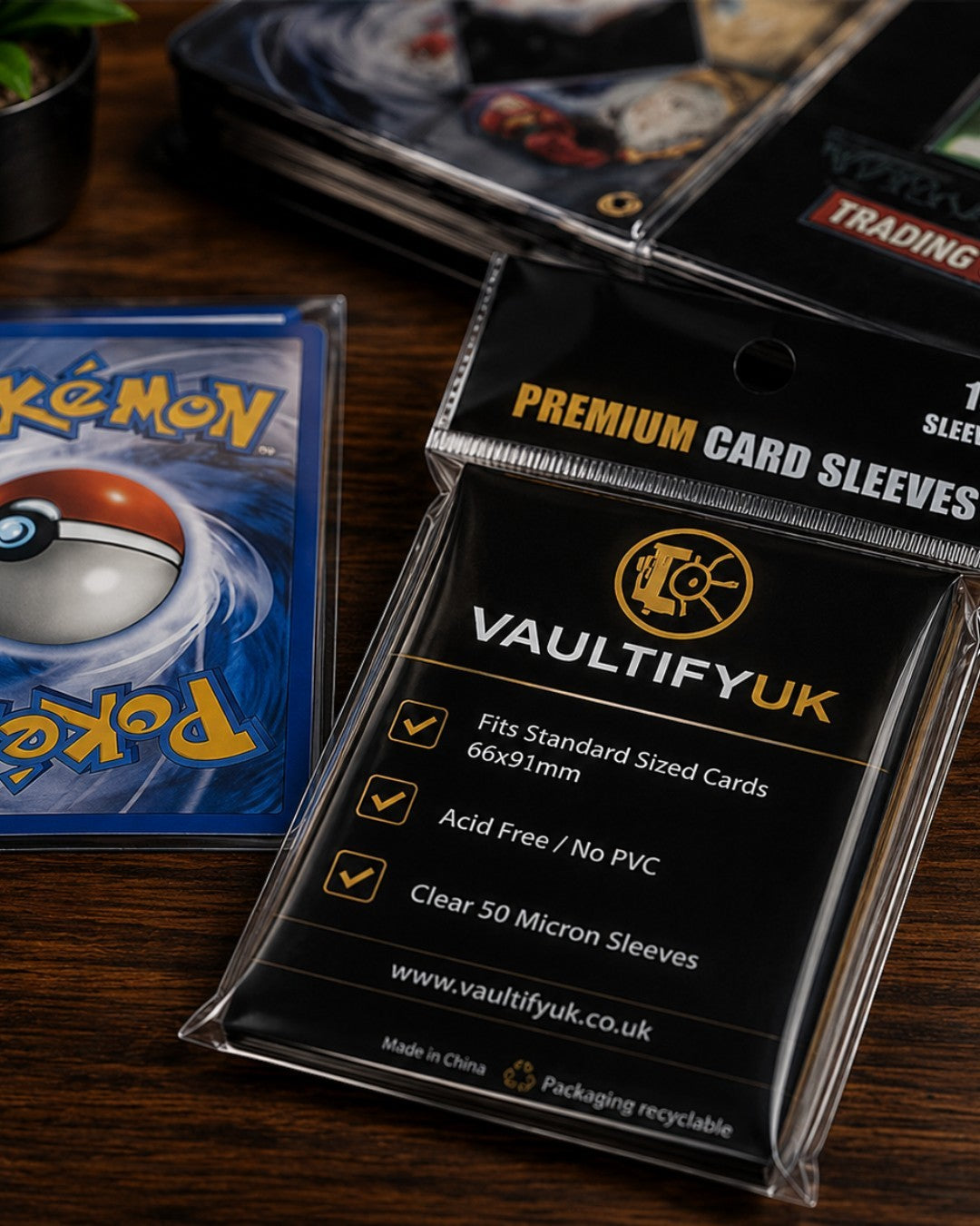 VaultifyUK Shield premium clear card sleeves for standard trading cards in retail packaging on a wooden desk