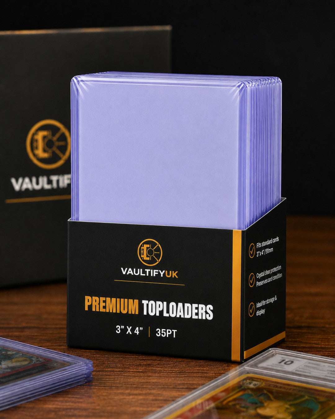 VaultifyUK Shield premium 35PT toploaders in a black display box for protecting trading cards on a wooden surface.