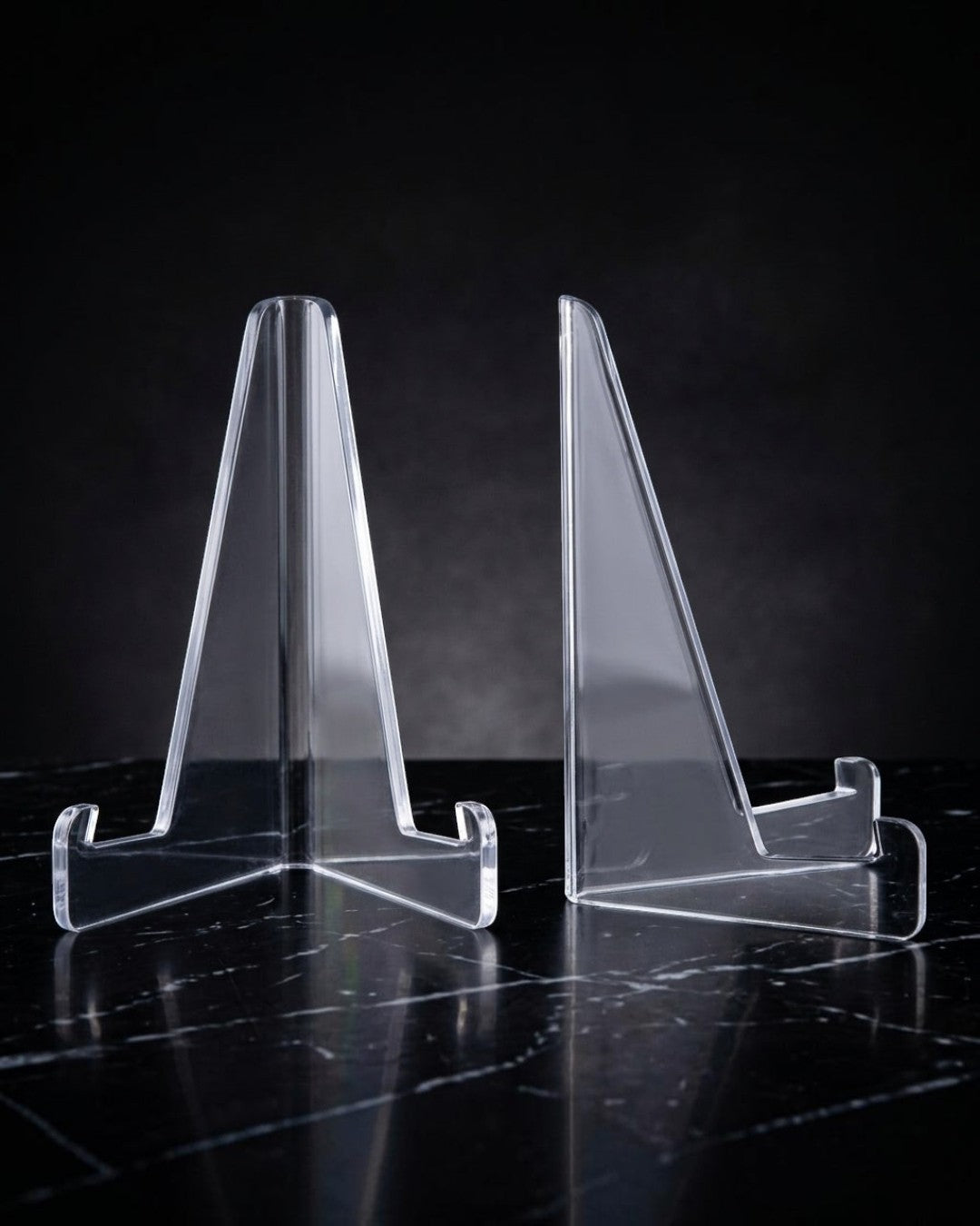 VaultifyUK Showcase clear acrylic display stands for trading cards and graded slabs on a black marble surface.