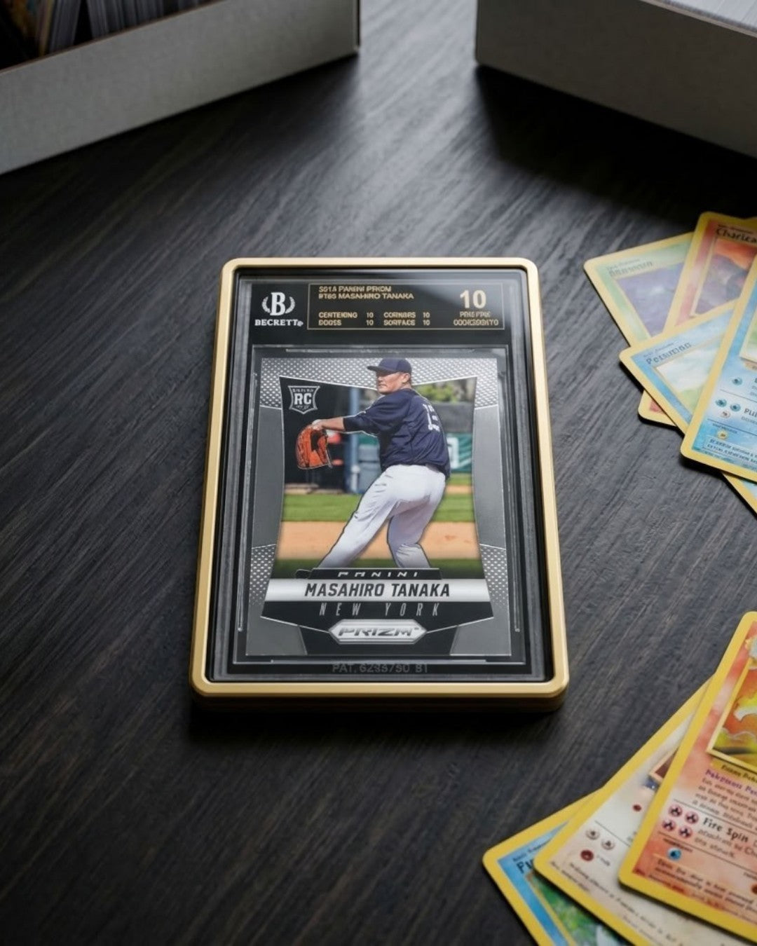 VaultifyUK Showcase gold aluminium display case protecting a graded BGS card on a dark wooden desk with magnifying glasses