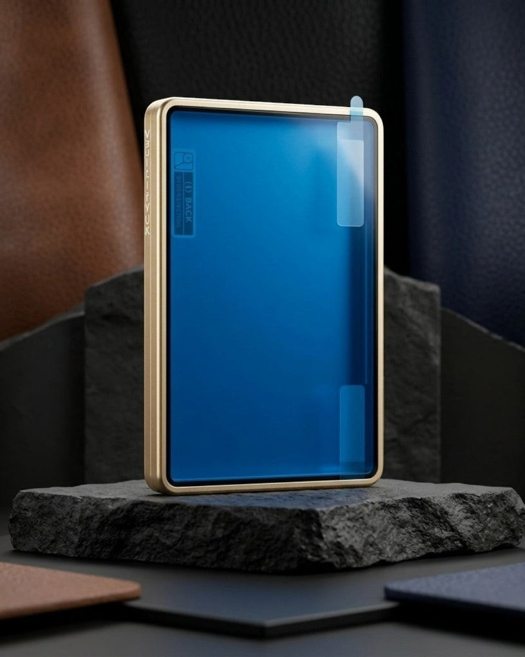 VaultifyUK Showcase gold aluminium PSA slab display case with protective film on a dark stone pedestal.