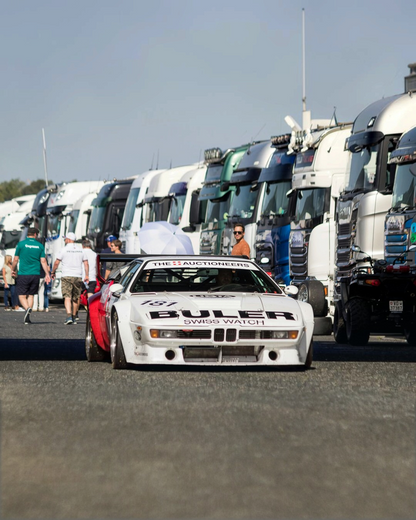 The real BMW M1 Procar: a white M1 Procar driving back to the paddock at a historic racing event