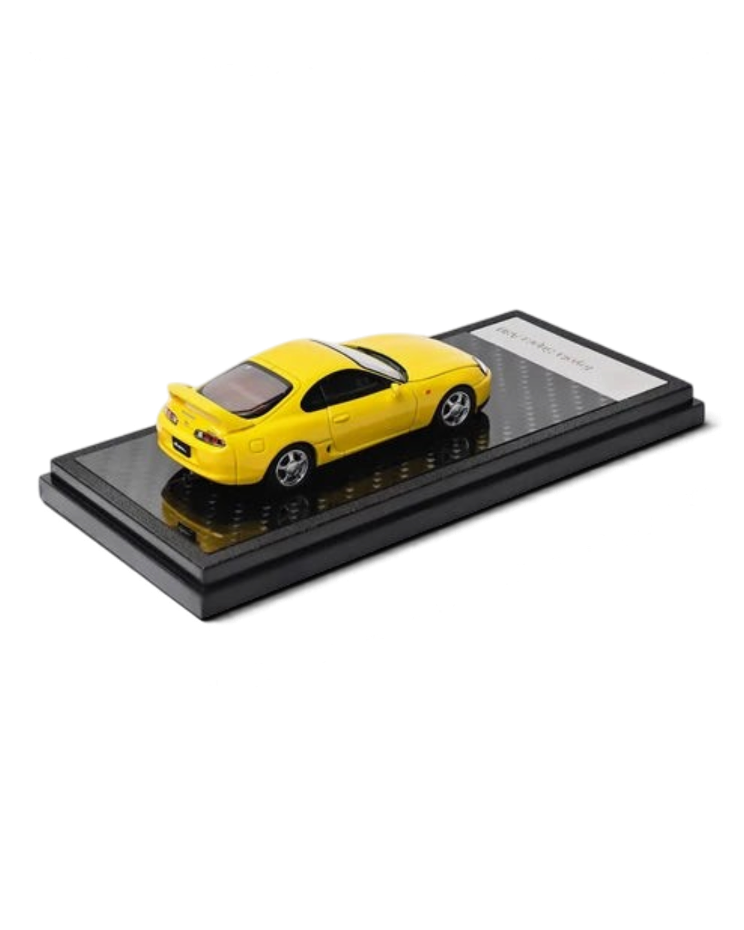 VaultifyUK yellow 1:64 scale LCD Models Toyota Supra A80 diecast car on a black display base with carbon fiber detail.