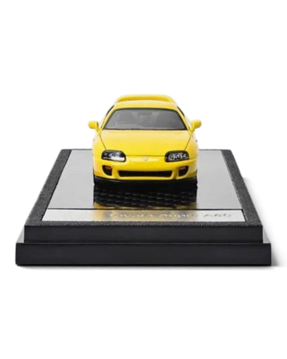 VaultifyUK yellow 1:64 scale LCD Models Toyota Supra A80 diecast car on a black display base, front view.