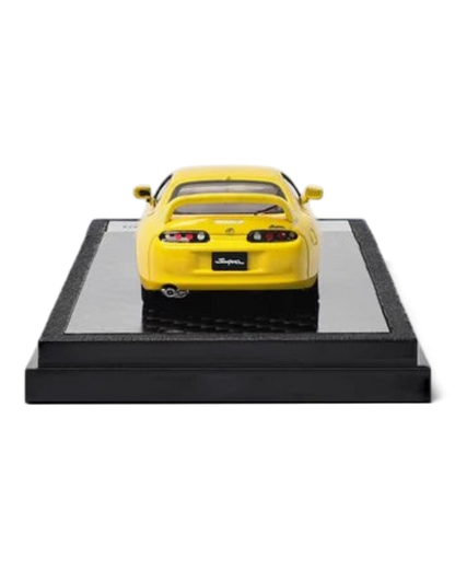 VaultifyUK yellow 1:64 scale Toyota Supra A80 diecast model car viewed from the rear on a black display base